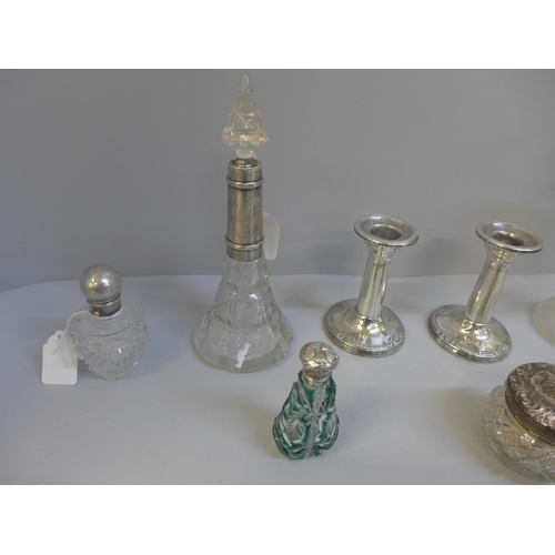 825 - A collection of silver topped and mounted glass jars and bottles, and a pair of silver candlesticks,... 