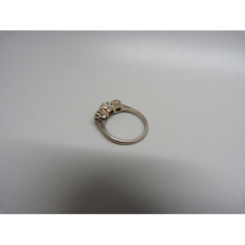 899 - An 18ct gold, three stone diamond ring, the centre stone approximately 0.75 carat weight, 3.7g, P