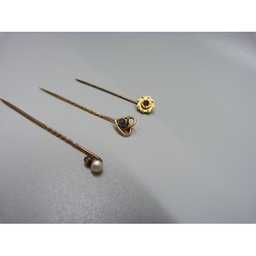 942 - Three stick pins, two marked 9ct and one set with an old cut diamond and a pearl, total weight 3.2g