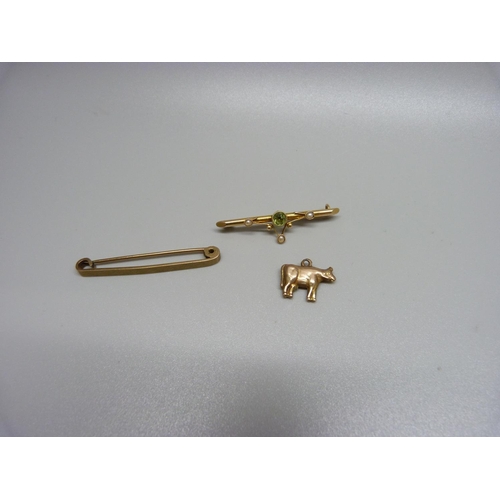 946 - A 9ct gold tie-clip, 2.4g, a peridot set brooch, a/f, 1.6g, and a yellow metal cow charm, 0.5g