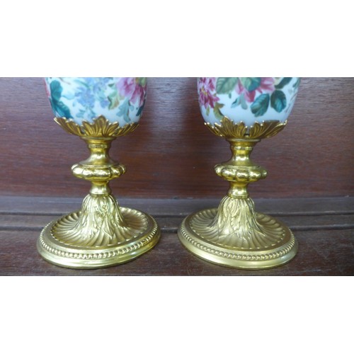 664 - A pair of gilt metal and ceramic garnitures