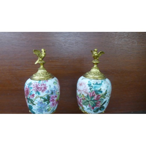 664 - A pair of gilt metal and ceramic garnitures