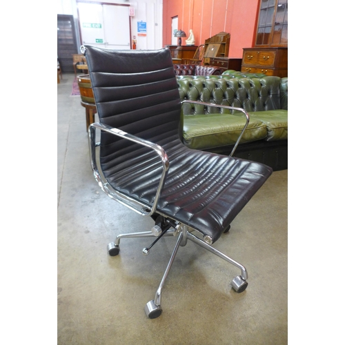 82 - An Eames style chrome and black leather revolving desk chair