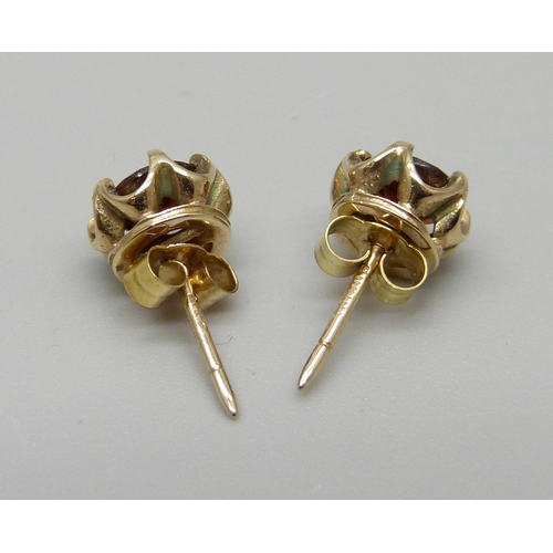 1119 - A pair of 9ct gold and garnet ear studs, 1.4g