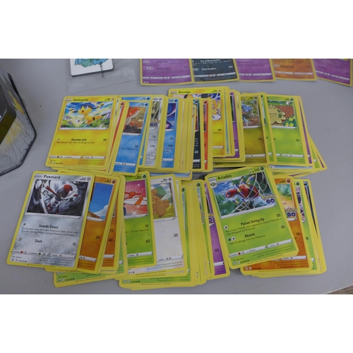 620 - Pokemon cards; a Pokemon collectors tin containing 150 basic Pokemon cards, five holographic cards a... 