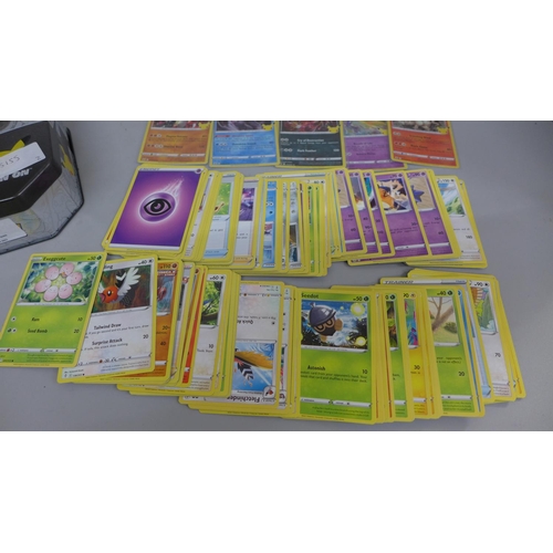 621 - Pokemon cards; a Pokemon collectors tin containing 150 basic Pokemon cards and five holographic card... 