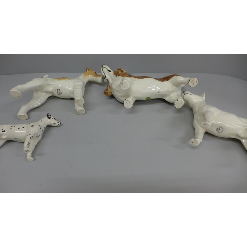 629 - Four Beswick dogs, including a Basset hound and a Dalmatian