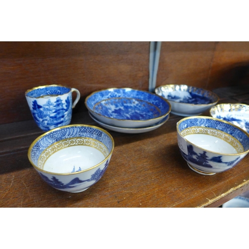 649 - A collection of Chinese export blue and white tea bowls and saucers and a cup, all with gilded decor... 