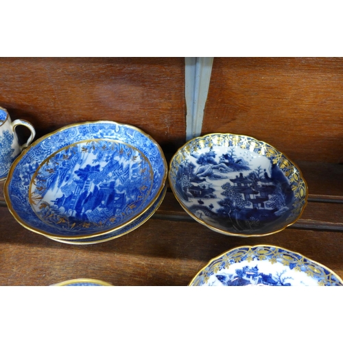 649 - A collection of Chinese export blue and white tea bowls and saucers and a cup, all with gilded decor... 