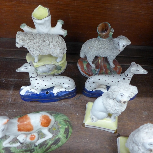 712 - A collection of Staffordshire animals, sheep, poodles, Dalmatians and lambs