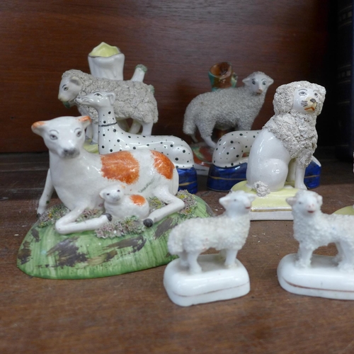 712 - A collection of Staffordshire animals, sheep, poodles, Dalmatians and lambs