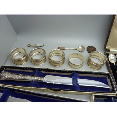 929 - Five silver handled knives, a cased set of six silver spoons, five silver napkin rings, silver sugar... 