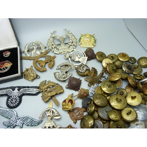 943 - Assorted military buttons and Regimental badges including two German cloth badges