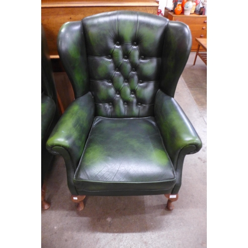 13 - A green leather Chesterfield wingback armchair