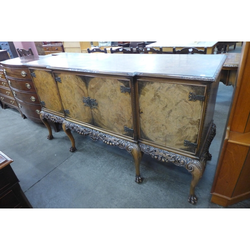 168 - An early 20th Century Queen Anne style carved burr walnut breakfront sideboard, retailed by Harrods,... 