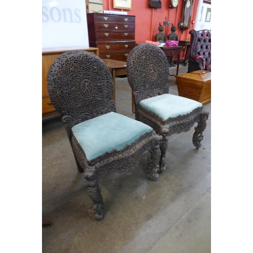 18 - A pair of Anglo Indian carved padouk wood chairs