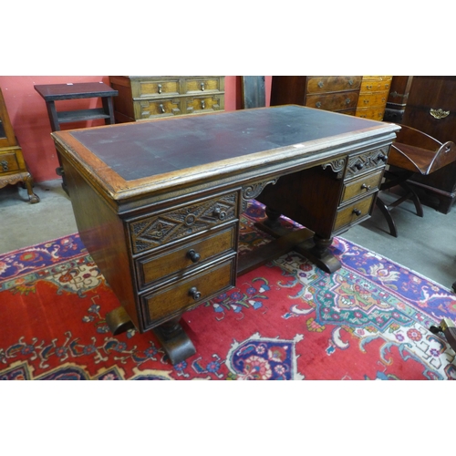 29 - A 17th Century style carved Ipswich oak and green leather topped desk