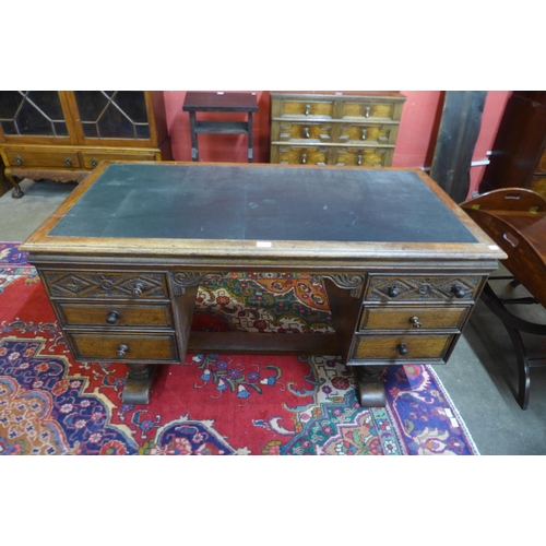 29 - A 17th Century style carved Ipswich oak and green leather topped desk