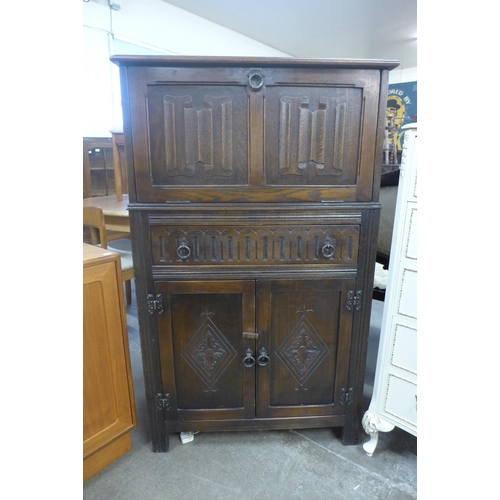 208 - A carved oak cocktail cabinet