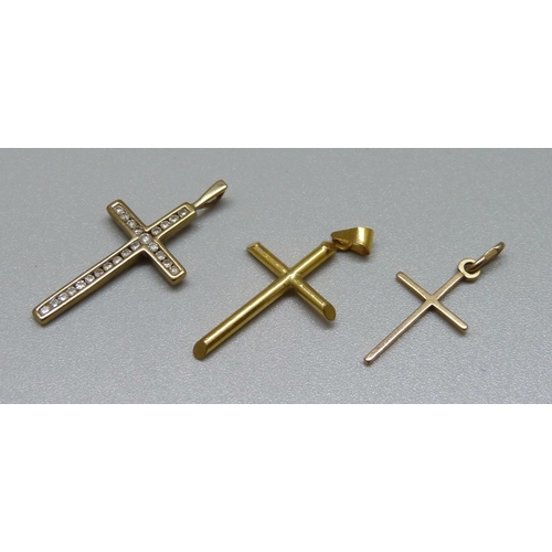 1006 - Two 9ct gold crosses, 0.8g and a yellow metal cross, 1.3g