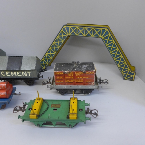 672 - Six Hornby O gauge pre-war wagons, a tinplate footbridge and a buffer stop