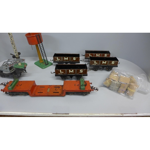 725 - Six O gauge Hornby wagons including a well wagon and a crane wagon with a tinplate signal and a wate... 