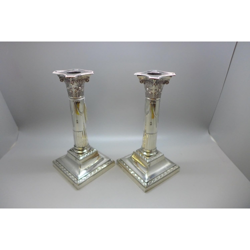 846 - A pair of Edwardian silver stop-fluted Corinthian column candlesticks, incurved canted beaded nozzle... 