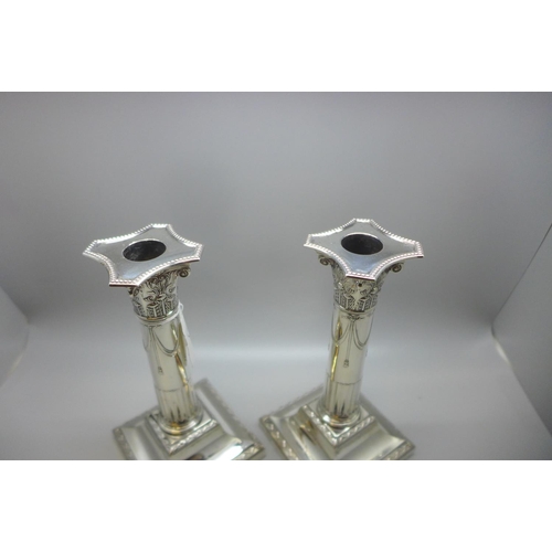 846 - A pair of Edwardian silver stop-fluted Corinthian column candlesticks, incurved canted beaded nozzle... 