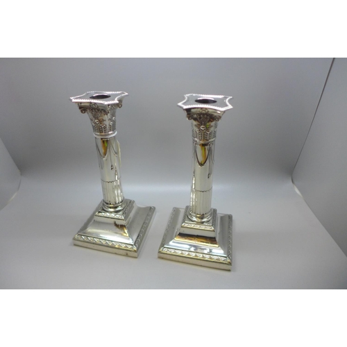 846 - A pair of Edwardian silver stop-fluted Corinthian column candlesticks, incurved canted beaded nozzle... 