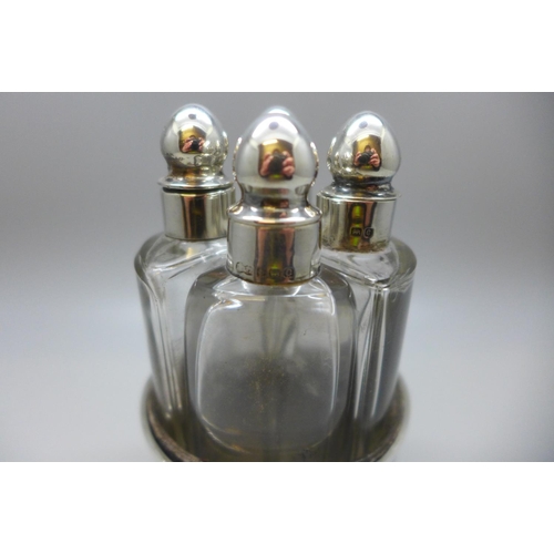 847 - Four silver topped perfume bottles, silver embossed themed holder, 49g, Chester 1903