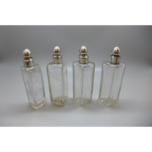 847 - Four silver topped perfume bottles, silver embossed themed holder, 49g, Chester 1903