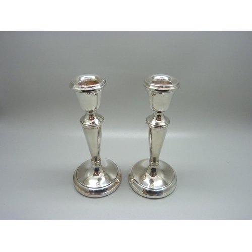 862 - A pair of silver candlesticks, weighted bases, 259g, one a/f