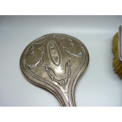 871 - A silver hand mirror and silver brush