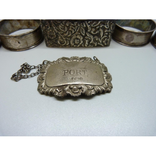 888 - A silver stamp box, four silver napkin rings and a silver port label, 128g