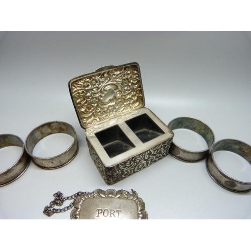 888 - A silver stamp box, four silver napkin rings and a silver port label, 128g