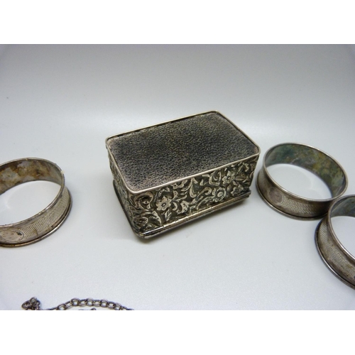 888 - A silver stamp box, four silver napkin rings and a silver port label, 128g