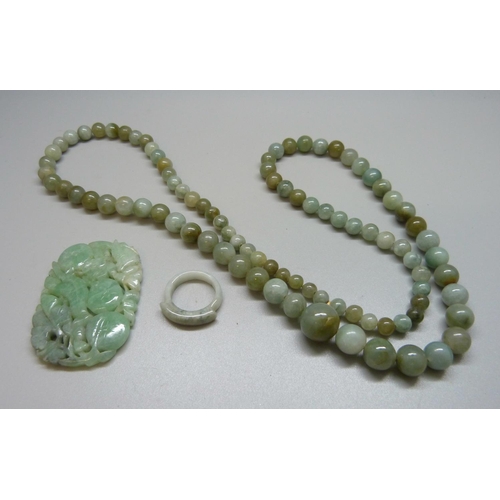 918 - A jade necklace, carved jade and a ring