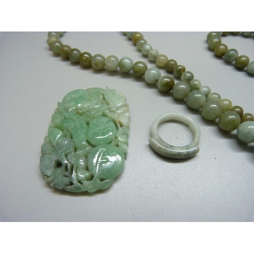 918 - A jade necklace, carved jade and a ring