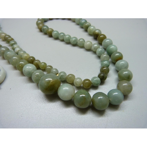 918 - A jade necklace, carved jade and a ring