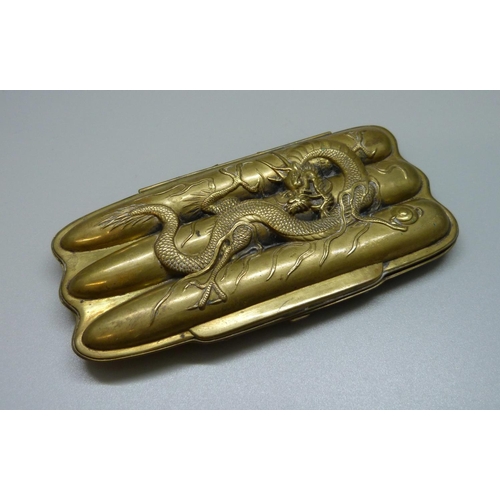 988 - A brass cigar case with an oriental dragon decoration