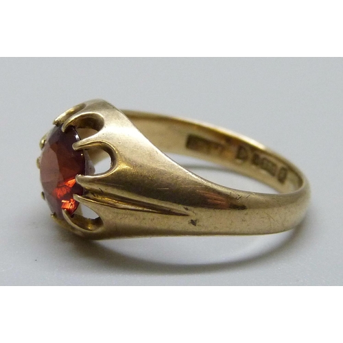 994 - A 9ct gold ring set with a red stone, 2.9g, L