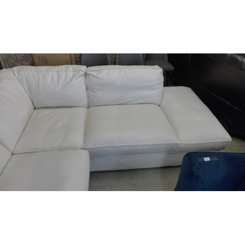 1560 - A Natuzzi two piece sectional cream leather sofa, original RRP £1916.66 + VAT, damaged leather on ba... 