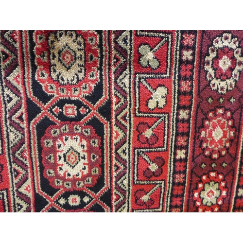 1582 - A rich red ground full pile Cashmere carpet with Beluchi design, 200cm x 300cm