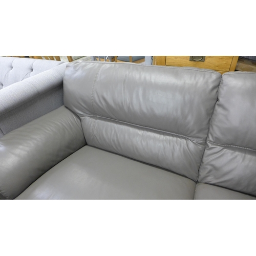 1526 - A grey leather three seater sofa - damaged leg