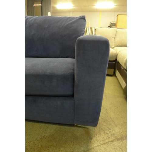 1563 - A blue velvet upholstered three seater sofa - stained on side