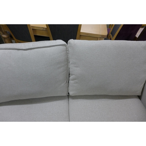 1577 - An oatmeal upholstered two seater sofa - odd cushion