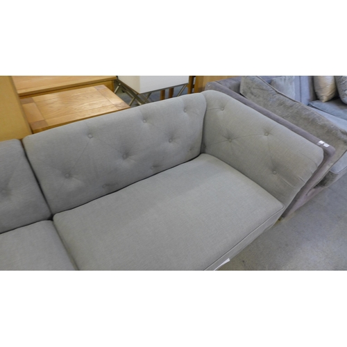 1578 - A grey buttoned four seater sofa - torn cushion