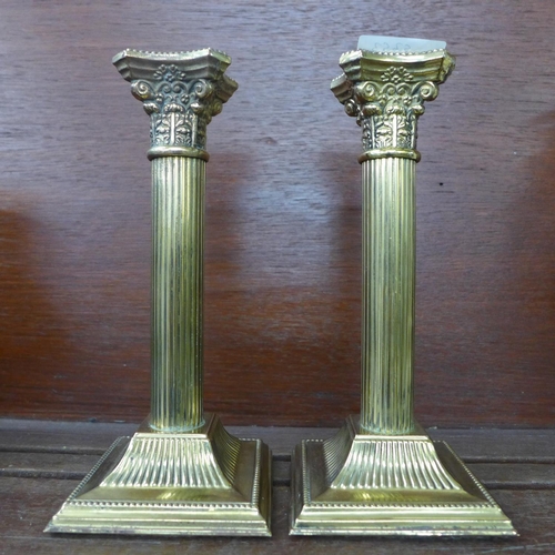 619 - A pair of brass Corinthian column candlesticks