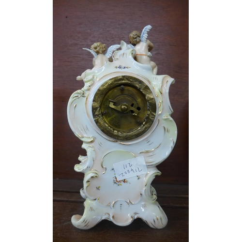 620 - A continental porcelain figural clock, with three cherubs and decorated with flowers