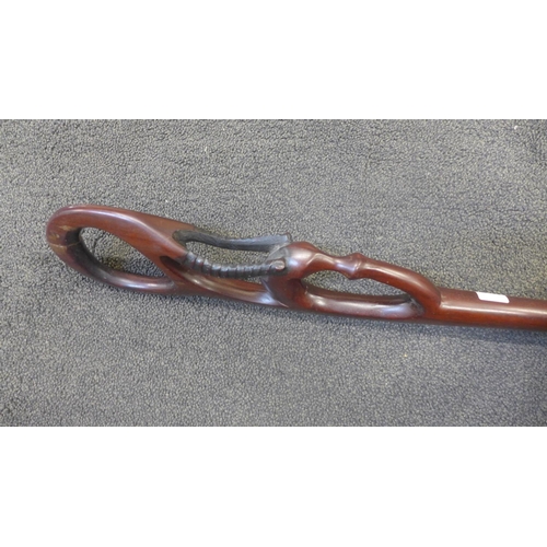 813 - A carved tropical hardwood African tribal staff with handle in the form of a stylised antelope